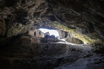 Photo from inside the Davelis Cave located in Penteli mountain next to the city of Athens -Greece. Beautiful colors of the rocks and a small ancient church at the entrance.