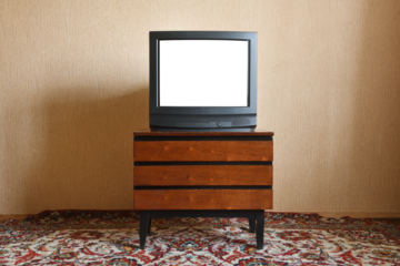 Old TV with white screen on vintage nightstand, vintage design in 80s and 90s style.