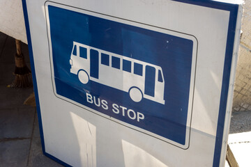 A sign on the sidewalk indicates a temporary city bus stop