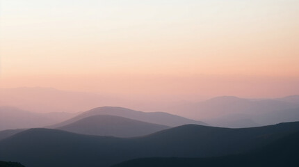 Obraz premium Pastel pink and purple sunset illuminating mountain ridges