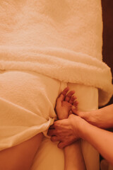 The hands of a chiropractor are massaging the hands of a young woman lying on a massage table. Physiotherapy treatment concept, neck pressure point. Wellbeing. No focus blurred