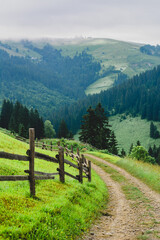 wooden fence in the village in the mountains. summer morning