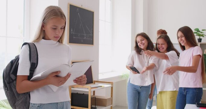 Teenage girl alone at school suffering from study problems, bulling, classmates abuse, aggressively dominate, hurtful social teasing, threat, psychological harm, lower exam result academic achievement