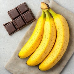 Ripe Bananas and Dark Chocolate on Gray Linen Background