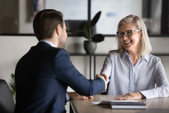 Two European business partners shake hands, met in office. Applicant and HR manager handshaking finish job interview successfully, candidate getting hired, expressing respect and appreciation. Trust