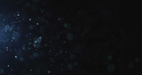 natural dust particles float in air on black background