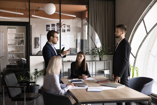 Project managers, leaders speaking in conference room, provide explanations, search issue solution, brainstorming on creative work ideas together, planning or developing startup strategy in boardroom