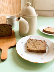 Old fashioned retro breakfast, sliced banana bread, served with pot of tea and cups