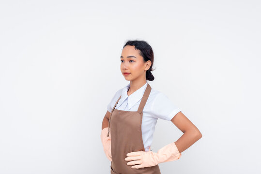 A stoic and composed young asian domestic helper, hands on hips. Isolated against a white background.