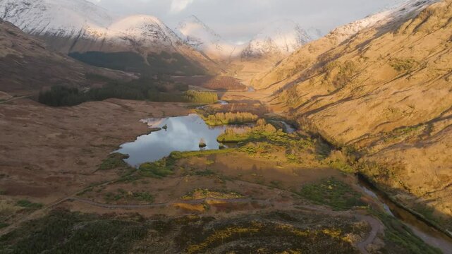 Dramatic Drone shot of Glen Etiv in the Scottish Highlands during winter at sunset 