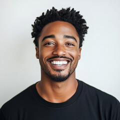 Smiling man with curly hair, wearing black shirt, isolated background
