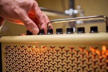 A musician is adjusting the amplifier settings for optimal sound quality during a performance