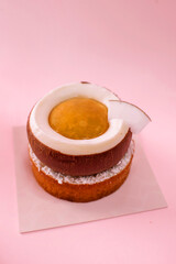 Dessert with cream in the shape of coconut isolated on the pink background