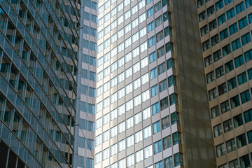 Close-up view of modern high-rise buildings with glass and metal façades reflecting sunlight, showcasing urban architecture