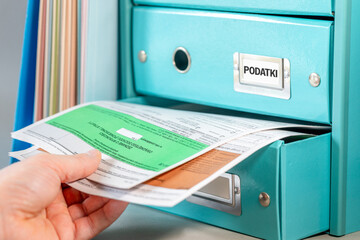Taxes Poland. Personal income tax settlement. Financial concept. Person reaching into a drawer for...
