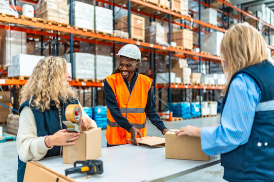 Multi-ethnic workers preparing parcels to deliver in a warehouse
