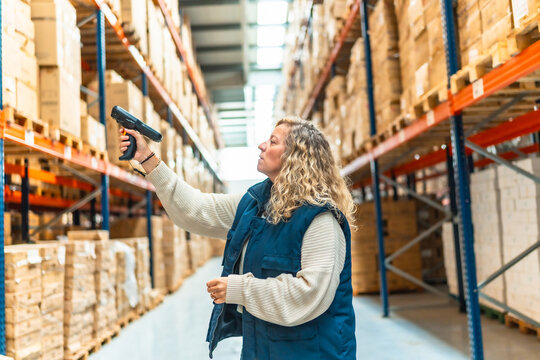 Woman tracking packages using scan reader in a warehouse