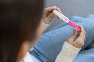 Sad, Disappointed motherhood asian young woman hand holding pregnancy test, upset ovulation...