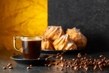 Black coffee in glass cup and coffee beans in motion on a black table.