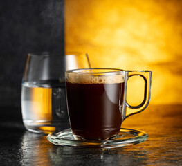 Espresso and glass of cold water on a black background.