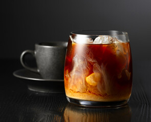 Iced coffee with cream and cup of black coffee.