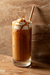 Iced caramel latte topped with whipped cream and caramel sauce.