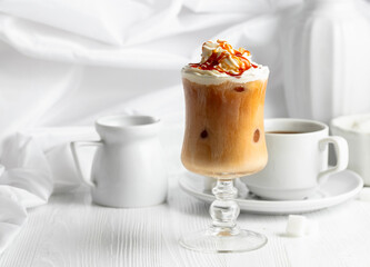 Iced caramel latte topped with whipped cream and caramel sauce.