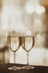 Soft blurred bokeh lights glowing beside elegant wine glasses, creating a romantic and intimate ambiance, style book illustration