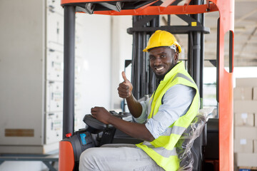 African American warehouse worker driving forklift car and show thumbs up in distribution storehouse