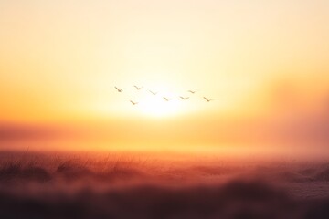 Obraz premium Serene Sunrise Over Misty Landscape with Flock of Birds Gliding Through the Golden Horizon in a Beautiful Nature Setting