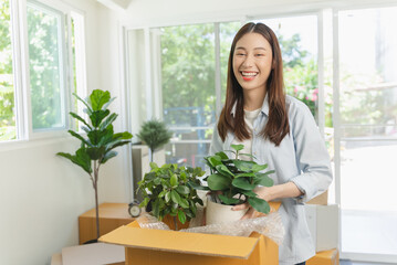 Asian couple checking the list of stuff before packing to cardboard for relocation move out of apartment.