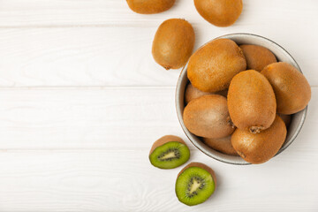 Kiwi on wooden background. Whole fruit and slices pieces of green kiwi on table. fresh ripe juicy kiwi. Tropical fruit. Organic fruit. Healthy eating. Space for text. Copy space.