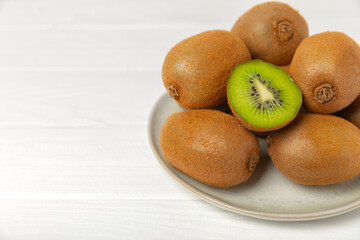 Kiwi on wooden background. Whole fruit and slices pieces of green kiwi on table. fresh ripe juicy...