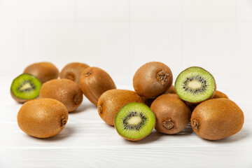 Kiwi on wooden background. Whole fruit and slices pieces of green kiwi on table. fresh ripe juicy...