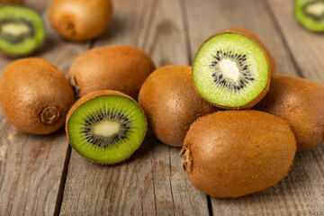 Kiwi on wooden background. Whole fruit and slices pieces of green kiwi on table. fresh ripe juicy...
