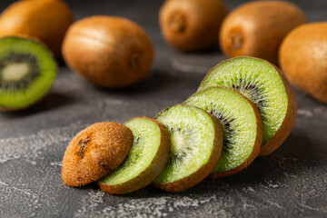 Kiwi on wooden background. Whole fruit and slices pieces of green kiwi on table. fresh ripe juicy...