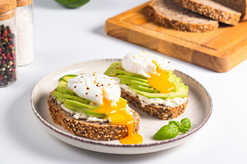 Two avocado open sandwiches with egg. Keto and diet concept. Healthy toast food for breakfast.