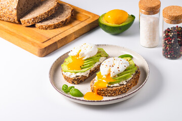 Two avocado open sandwiches with egg. Keto and diet concept. Healthy toast food for breakfast.