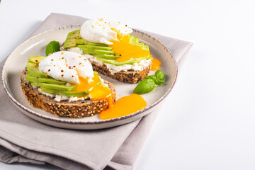 Two avocado open sandwiches with egg. Keto and diet concept. Healthy toast food for breakfast.