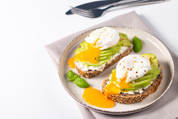 Two avocado open sandwiches with egg. Keto and diet concept. Healthy toast food for breakfast.