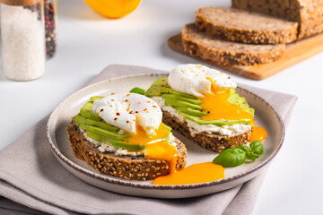 Two avocado open sandwiches with egg. Keto and diet concept. Healthy toast food for breakfast.