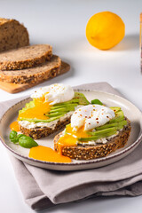 Two avocado open sandwiches with egg. Keto and diet concept. Healthy toast food for breakfast.