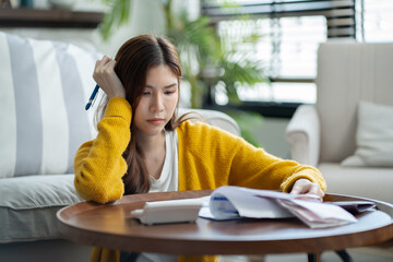 stressed woman trying money to pay credit card debt and worry by calculate expense from invoice or...
