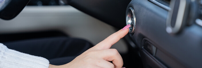 The female driver is trying to start the car's engine.