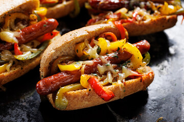 Close up of sausage sandwich with colorful peppers and onion. Hot dog form with added vegetables