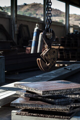 Clamp for lifting sheet metal with a crane. Clamp for moving metal plates with thick metal plates lying next to them