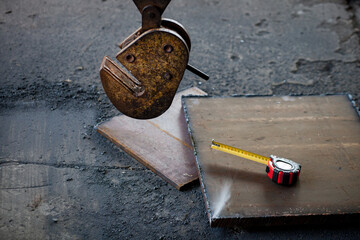 Clamp for lifting sheet metal with a crane. Clamp for moving metal plates with thick metal plates lying next to them