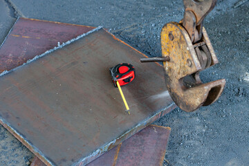 Clamp for lifting sheet metal with a crane. Clamp for moving metal plates with thick metal plates lying next to them