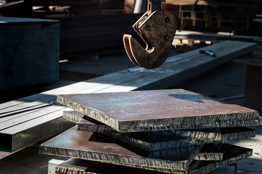 Clamp for lifting sheet metal with a crane. Clamp for moving metal plates with thick metal plates lying next to them