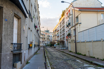 Obraz premium Charming cobblestone street in a quiet neighborhood at sunset